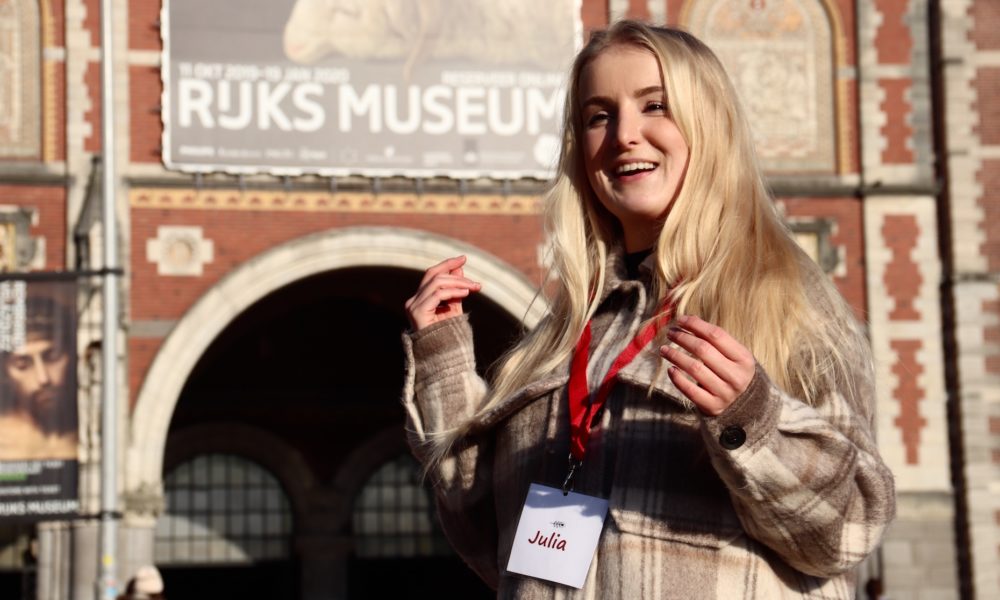 Tourist with a lanyard in front of Rijks Museum. The museum is famous for its Dutch art and history.