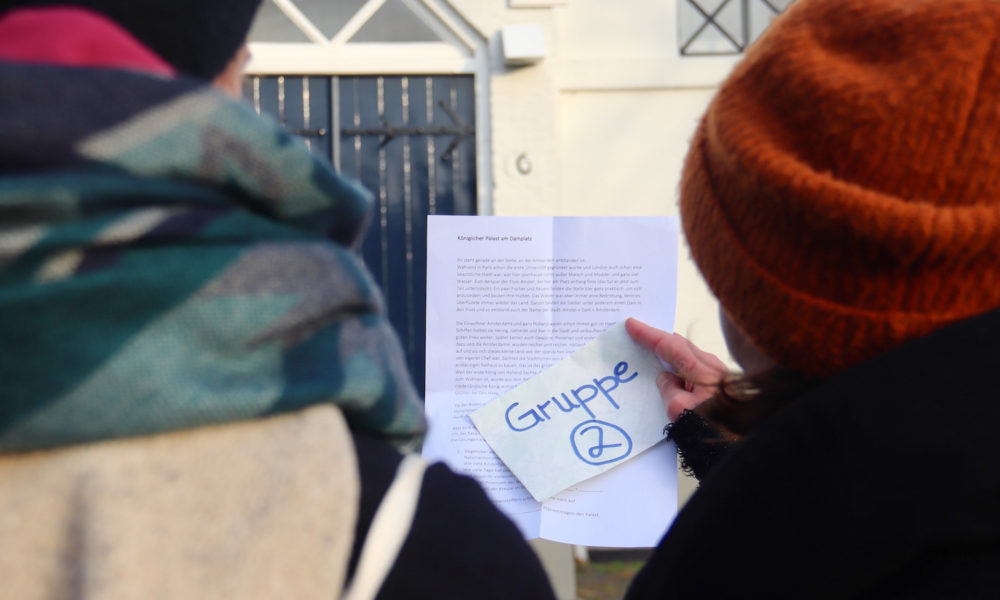 Amsterdamliebe Schnitzeljagd Teilnehmer schauen sich das Aufgabenblatt an