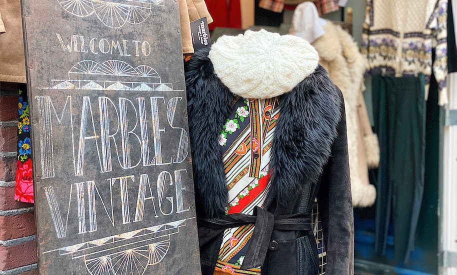 Marbels Vintage Tafel am Eingang des Ladens mit angezogener Schaufensterpuppe