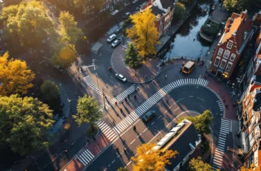 Aerial view of a busy street in Amsterdam. Cars and a bus on a curved road.