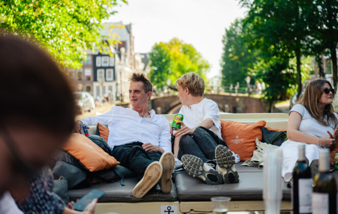 Tourists on a guided boat tour through the canals of Amsterdam