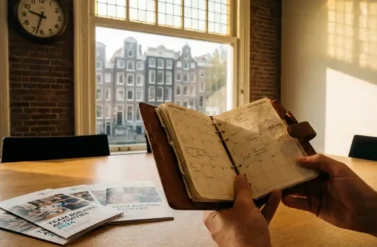 Businesswoman holding open planner in Amsterdam office with canal view and team building brochures on conference table